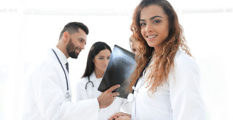 confident doctors in hospital looking at x-ray.