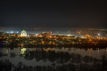 Night cityscape photographed from above. River flood in the spring.