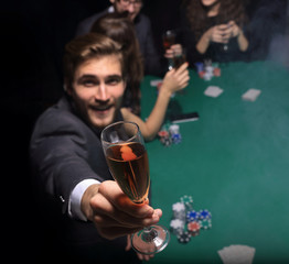 poker player raising a glass of wine