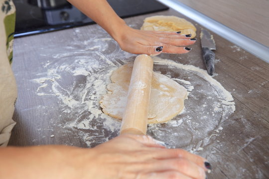 Wooden rolling pin in woman hands