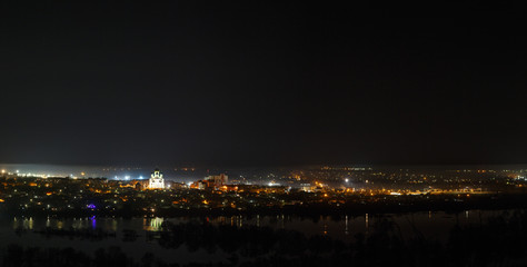 Night cityscape photographed from above. River flood in the spring. Panoramic view of the starry space.