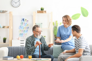 Caregiver with senior man and his son at home