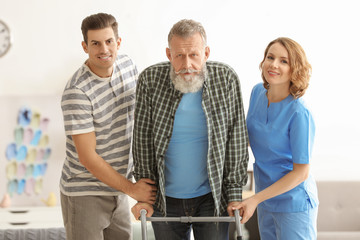 Caregiver with senior man and his son at home