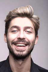 Fototapeta premium Bliska portret uśmiechnięty mężczyzna na szarym tle