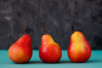 Bright red williams pears on turquoise background.