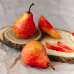 Bright red williams pears on linen wrimkled textile background. Ripe fruit in pastel colors
