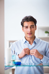 Man is getting dressed up for work in bathroom