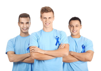 Young men in t-shirts with blue ribbons on white background. Prostate cancer awareness concept