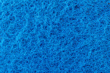 Fototapeta na wymiar texture of a surface of intertwined blue threads, abrasive of a synthetic fiber, abstract background