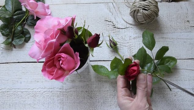 Top view of female decorator arranging roses on the wooden table, Concepts - fiorist, occupation, hobby, small business