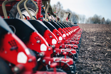 sewing machine with discs stands on the ground in the field in the spring