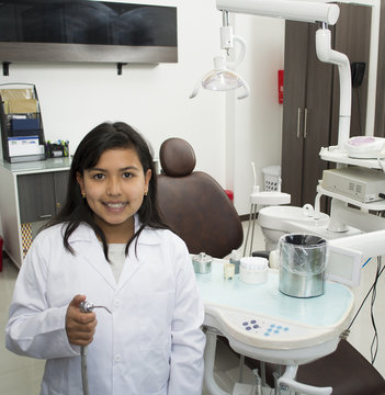 Child girl doctor posing in a dentist office.