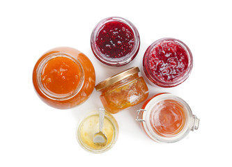 Jars with different sweet jam on white background