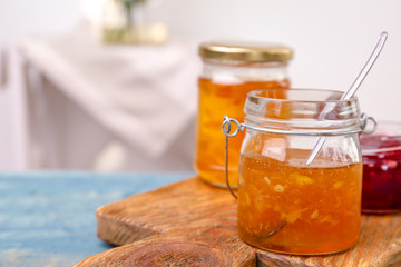 Jars with tasty sweet jam on wooden table