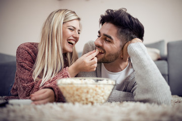 Young couple watch TV on the  floor