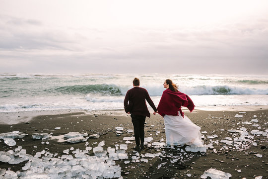 Beautiful Newlyweds Is Walking On Black Sand Beach, Iceland. Artwork