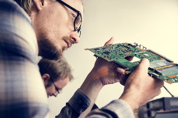 Side view of technician working on computer mainboard