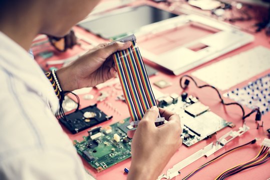 Technician holding flexible flat cable at workshop