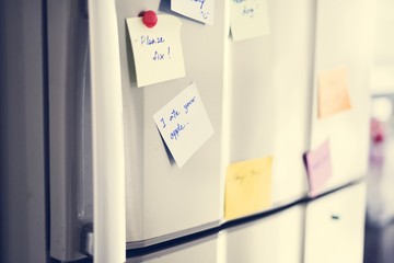 Closeup of reminder paper note on fridge door