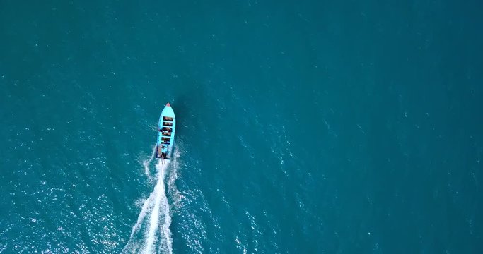 AERIAL 4K: Thailand long-tail boat, floats and move forward in the middle of the the sea. Wooden motor boat floating in the clear water,loopable
