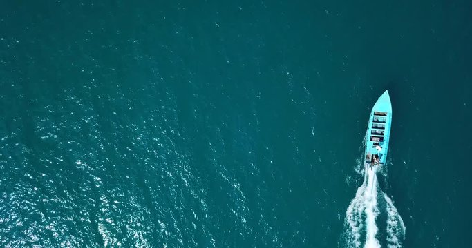 AERIAL 4K: Thailand long-tail boat, floats and move forward in the middle of the the sea. Wooden motor boat floating in the clear water,loopable