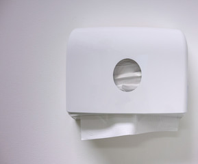 White box of tissues hanging on wall in toilet