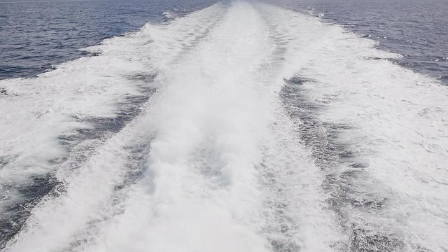 Background of water trail foaming behind a ferry boat.