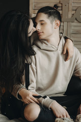 Young and beautiful couple flirting and kissing in a cozy home.