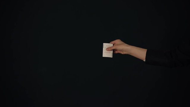 Young man showing tricks with cards in the dark