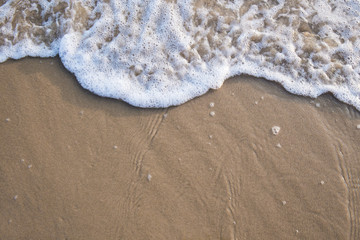 The movement of the waves on the sand is smooth and fine for  background,