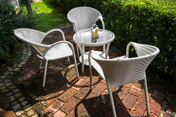 Wicker furniture, outdoor chairs and glass tables on the garden terrace.