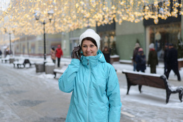 woman talking on phone on city street in winter