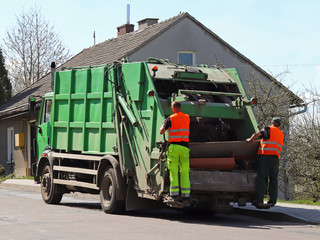 Carriage of garbage by the municipal service. Two janitors load garbage into the garbage truck....