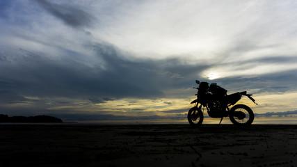 Fototapeta na wymiar motorcycle on beach and near ocean during sunset. adventure style.