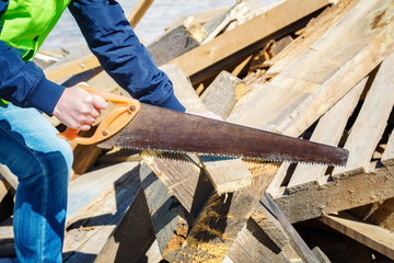 Woman worker saws plank