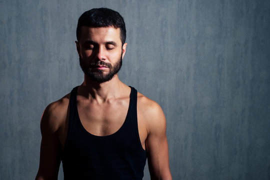 muscular healthy man in black T-shirt on dark background. concept of a healthy body and sexuality