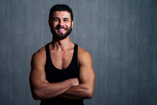 muscular healthy man in black T-shirt on dark background. concept of a healthy body and sexuality