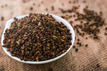 Close up of Coriander seeds in bowl on wooden background