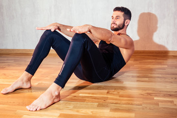 Fototapeta na wymiar A muscular man does exercises to strengthen the abdominal muscles on the floor. push-up from the floor. concept of health promotion and beautiful body. muscular and beautiful belly press
