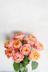 beautiful roses flowers in a vase on a table . Bouquet of pink and orange multicolor flower. Decoration of home. Wallpaper and background. Vertical photo