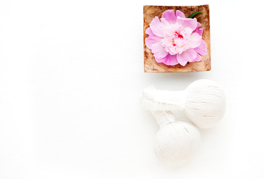 Herbal Thai massage balls and flower in a bowl with water. Spa concept. Flat lay
