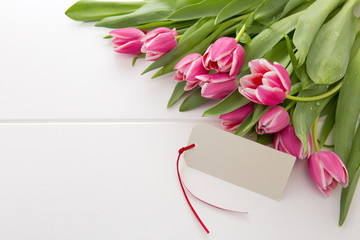 Mother's Day card and a bouquet of beautiful tulips on wooden background.