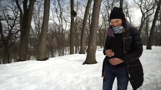 Beautiful pregnant woman in winter park