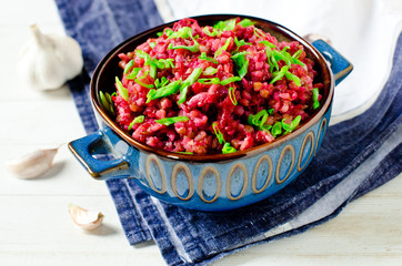 Buckwheat stewed with beetroot in a bowl on a wooden table