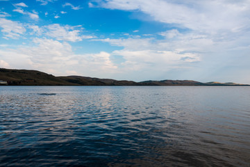 Lake and white clouds under lake in a sunny day