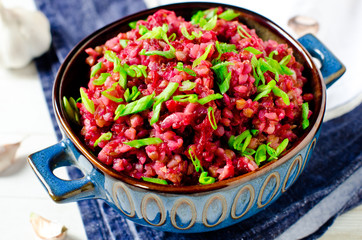 Buckwheat stewed with beetroot in a bowl on a wooden table