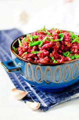 Buckwheat stewed with beetroot in a bowl on a wooden table