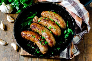 Foto auf Acrylglas Homemade sausages from turkey (chicken) fried in a frying pan © teleginatania