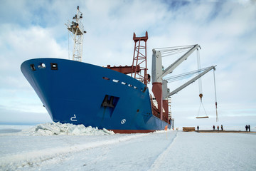 Against the backdrop of the arctic landscape, the ship unloads cargo onto the ice.. © Евгений Плотников