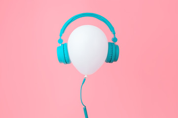 White balloon with tiffany color headphones on Pink background. Contemporary design. Trendy colors.